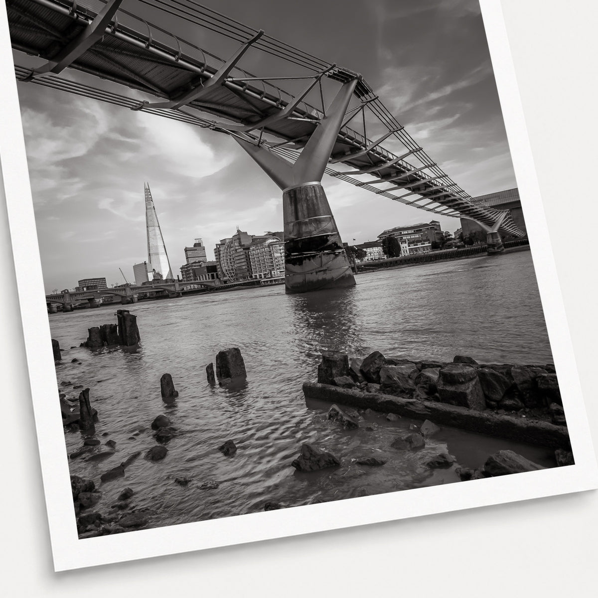 A black and white photographic print of Low Tide, shown with a white border and angled presentation on a light background.