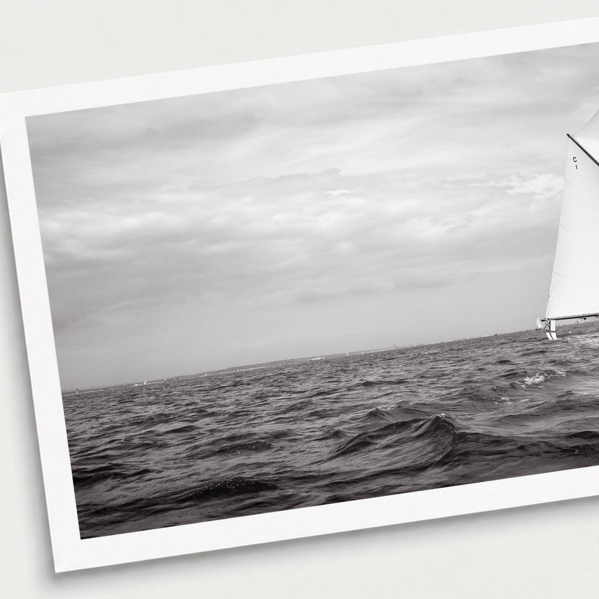 A black and white photographic print of Sail Away, shown with a white border and angled presentation on a light background.
