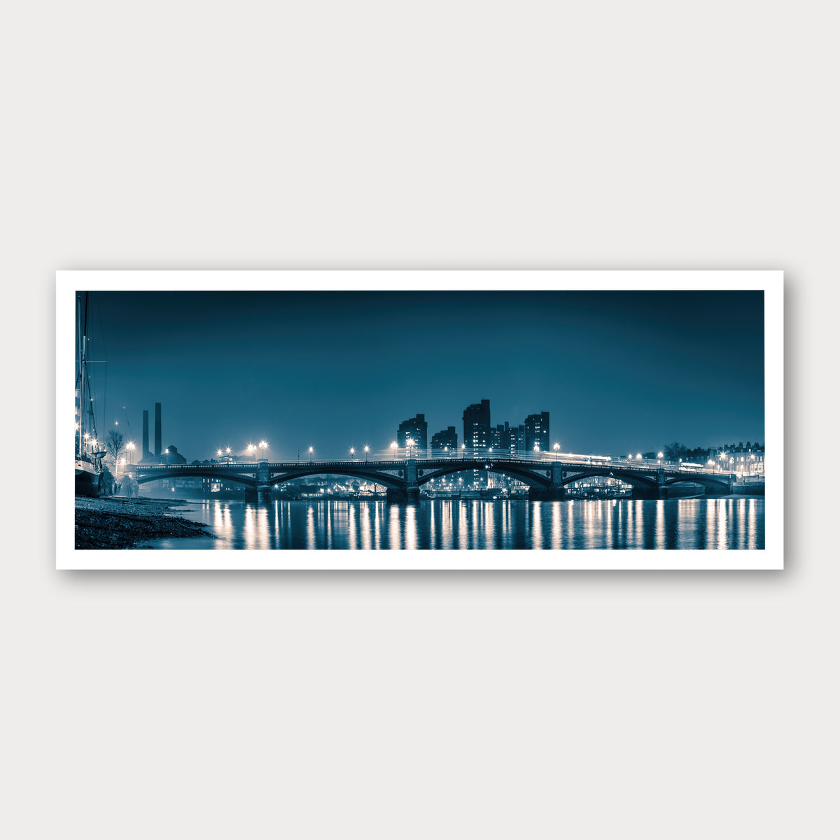 A photographic print of Battersea Bridge, framed with a white border and shown against a light gray background.