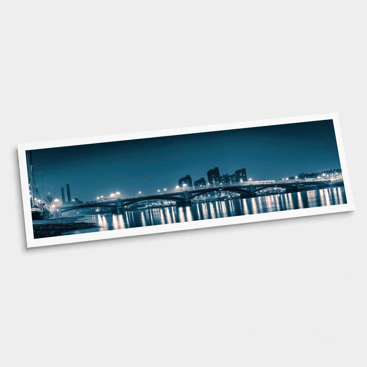 A photographic art print of Battersea Bridge, displayed at an angle on a light gray background.