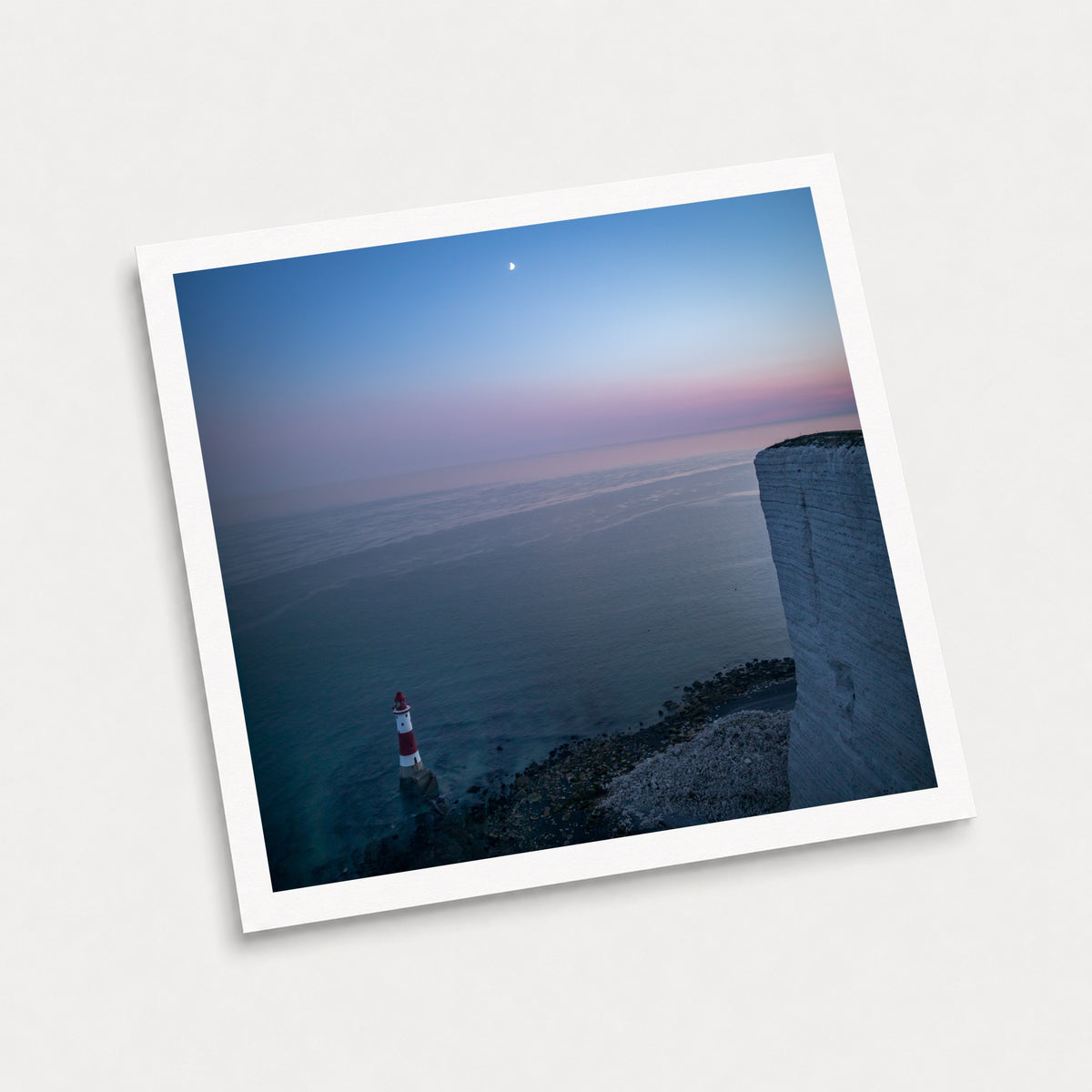 A photographic art print of Beachy Head by Night, displayed at an angle on a light gray background.