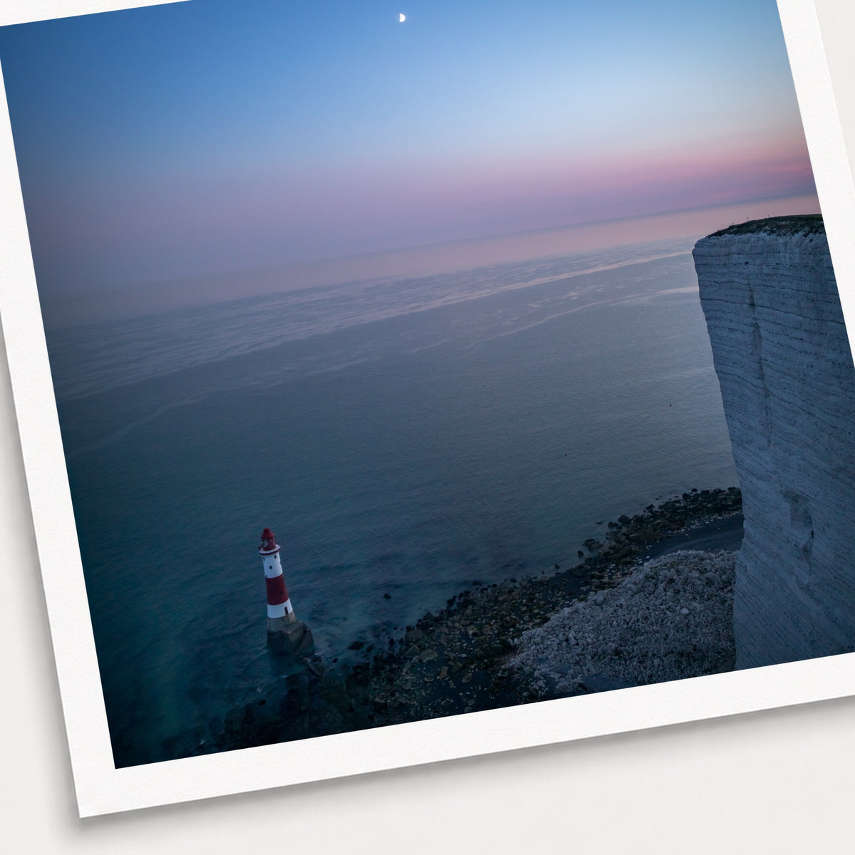 A photographic print of Beachy Head by Night, shown with a white border and angled presentation on a light background.