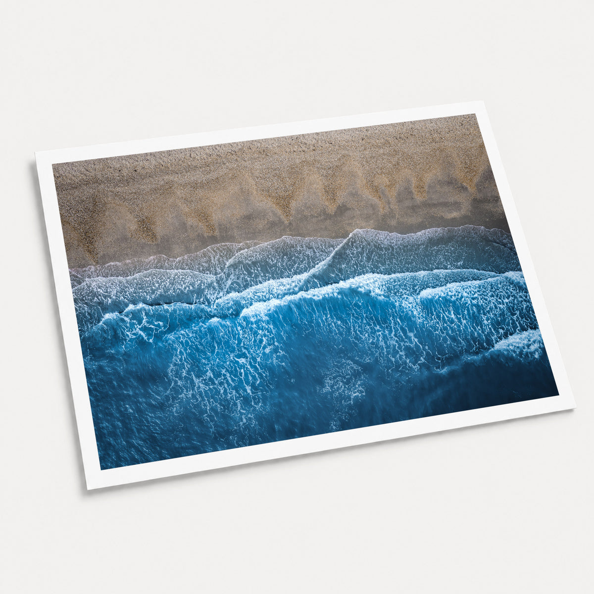 A photographic art print of Breaking Blue, displayed at an angle on a light gray background.