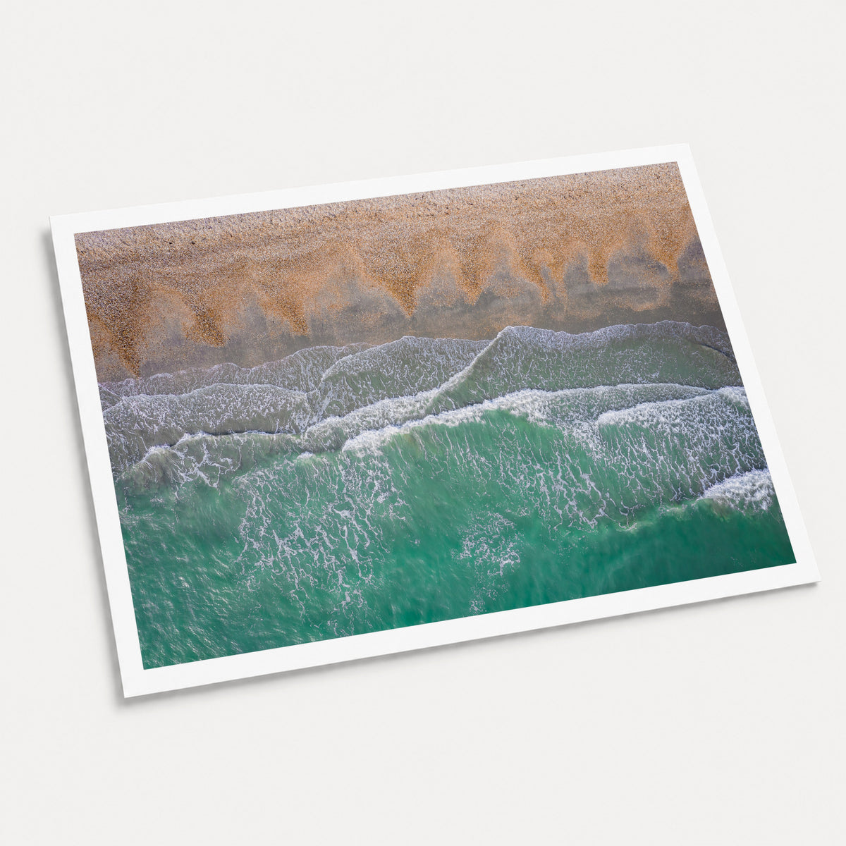 A photographic art print of Breaking Emerald, displayed at an angle on a light gray background.