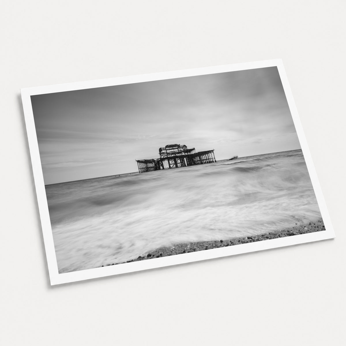 A photographic art print of Brighton Old Pier, displayed at an angle on a light gray background.