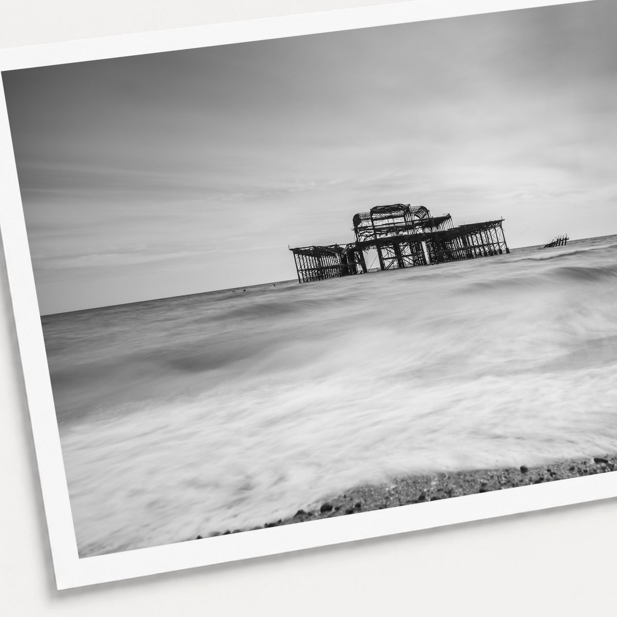 A photographic print of Brighton Old Pier, shown with a white border and angled presentation on a light background.