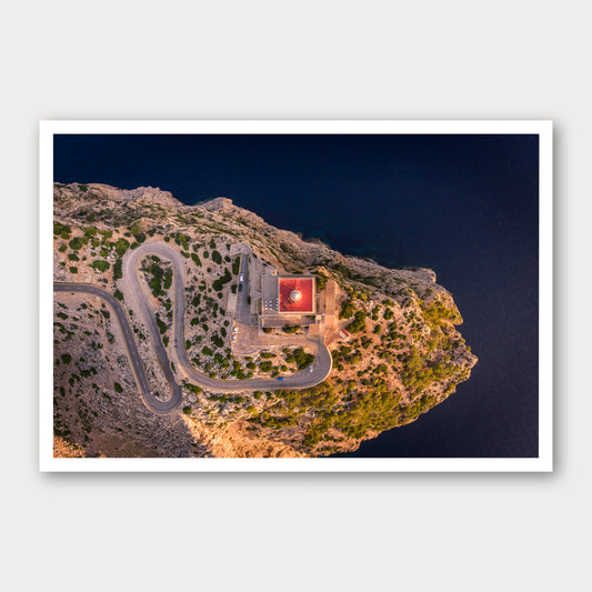 A photographic print of Cap De Formentor Lighthouse from above, framed with a white border and shown against a light gray background.