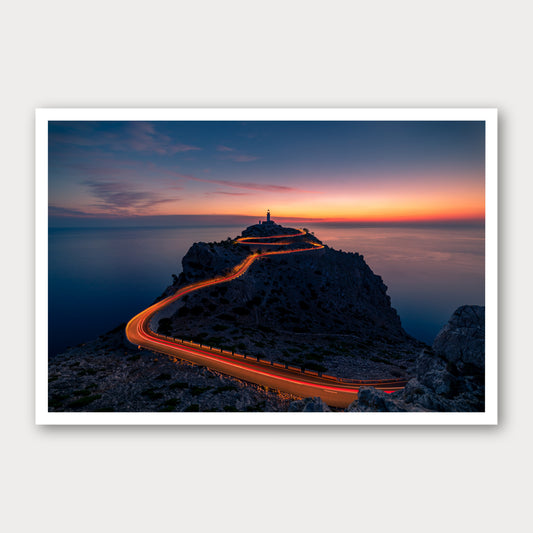 A photographic print of Cap De Formentor Lighthouse, framed with a white border and shown against a light gray background.