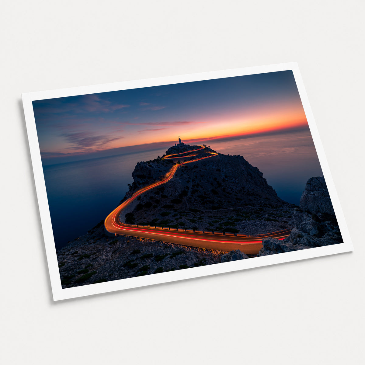 A photographic art print of Cap De Formentor Lighthouse, displayed at an angle on a light gray background.