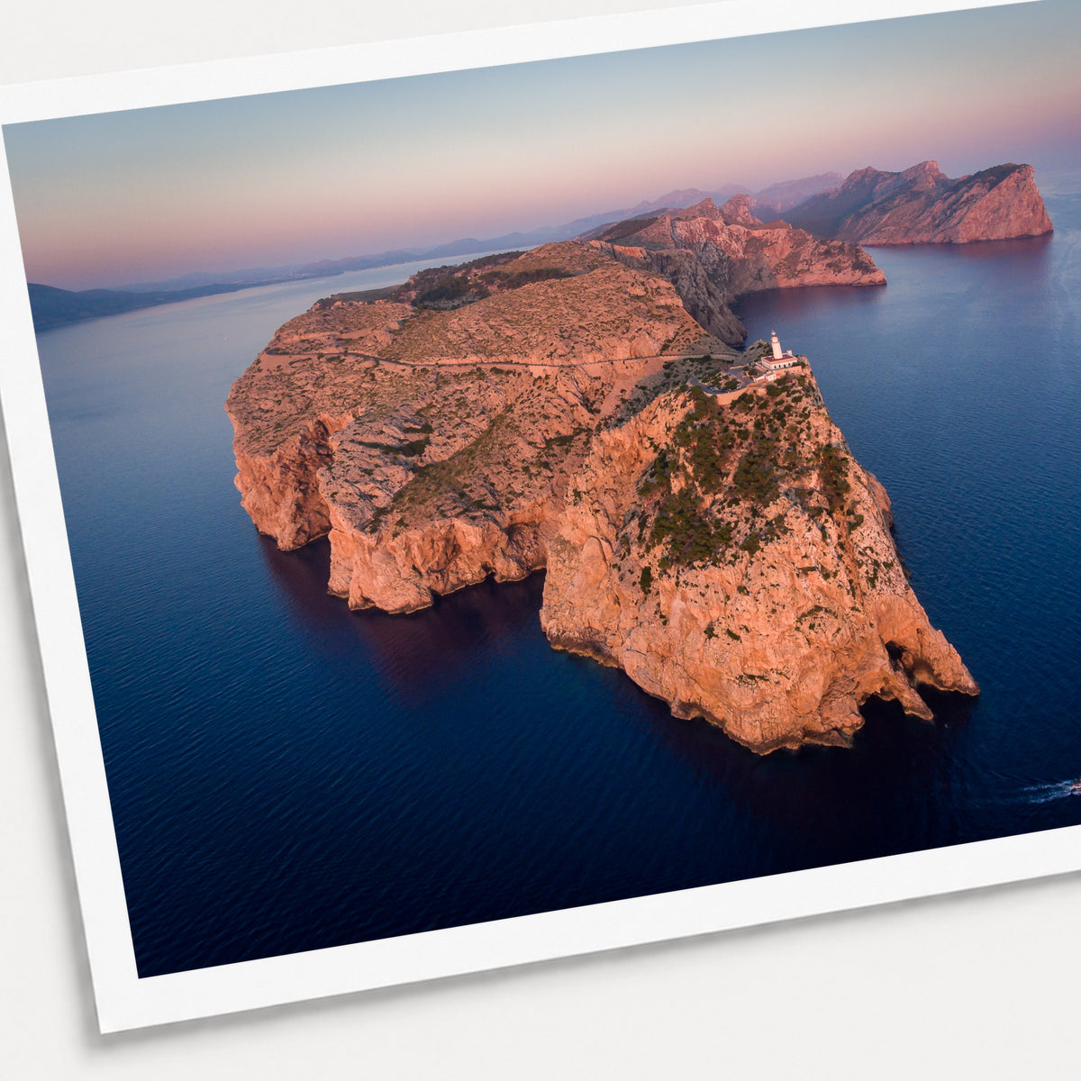 A photographic print of Cap De Formentor, shown with a white border and angled presentation on a light background.