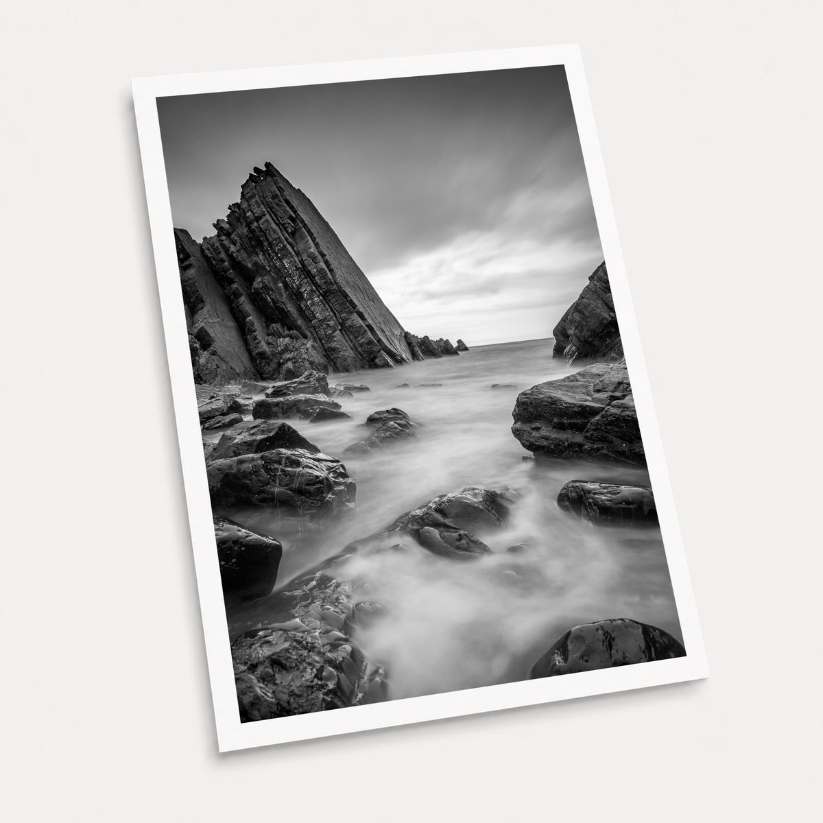 A black and white photographic art print of Cloudy Waters, displayed at an angle on a light gray background.