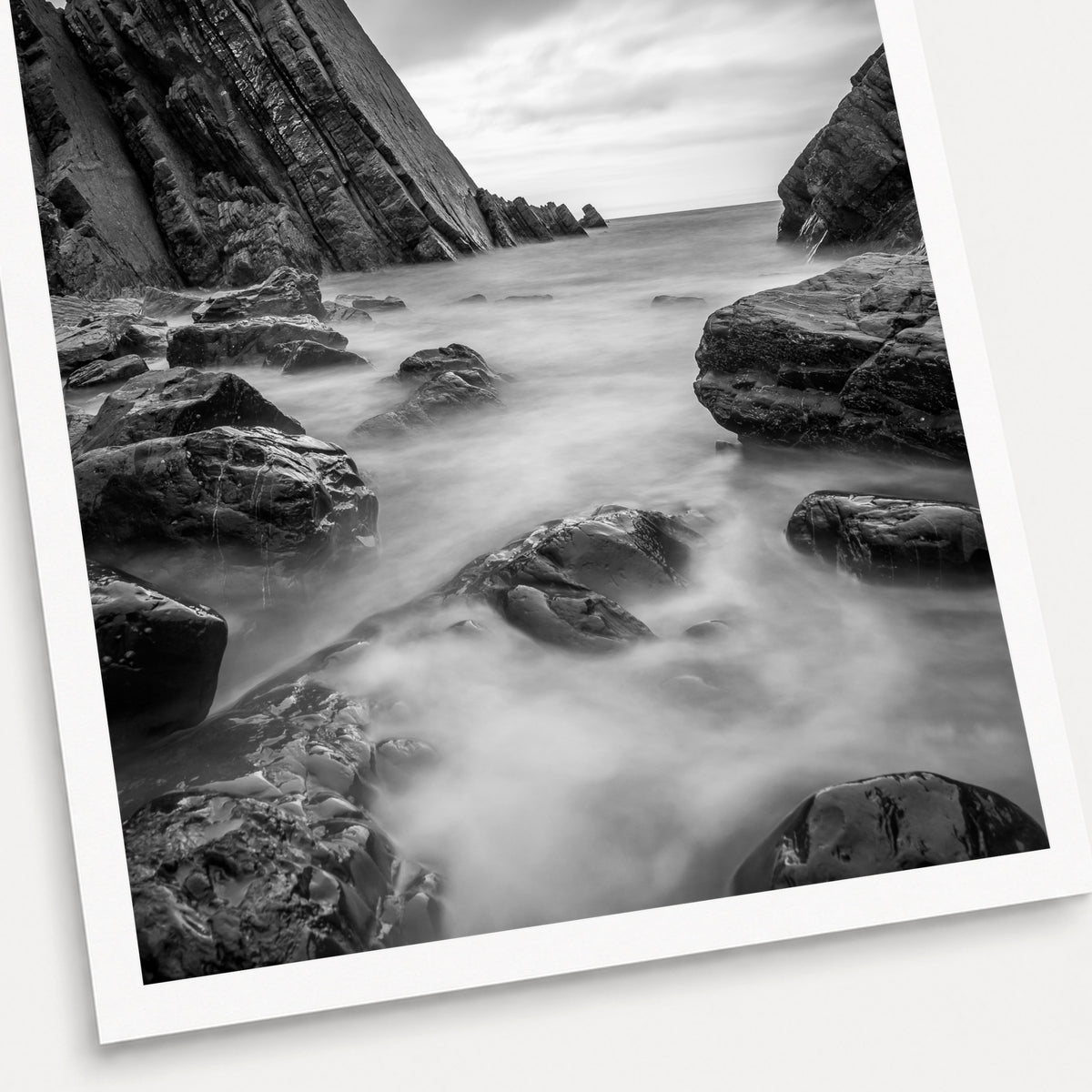 A black and white photographic print of Cloudy Waters, shown with a white border and angled presentation on a light background.