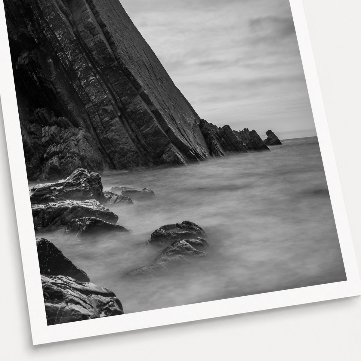 A black and white photographic print of Dragon's Back, shown with a white border and angled presentation on a light background.