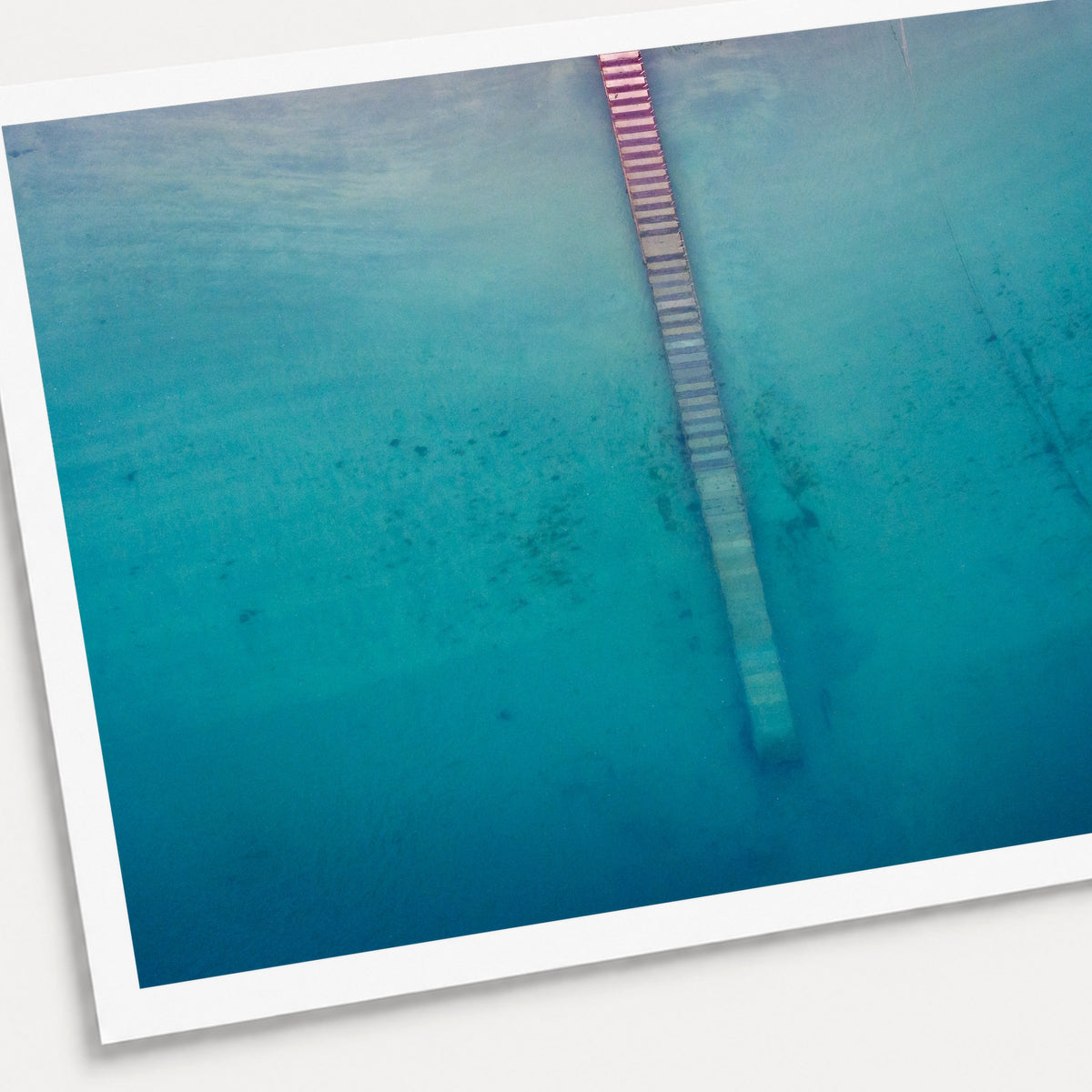 A photographic print of Jetty from Above, shown with a white border and angled presentation on a light background.