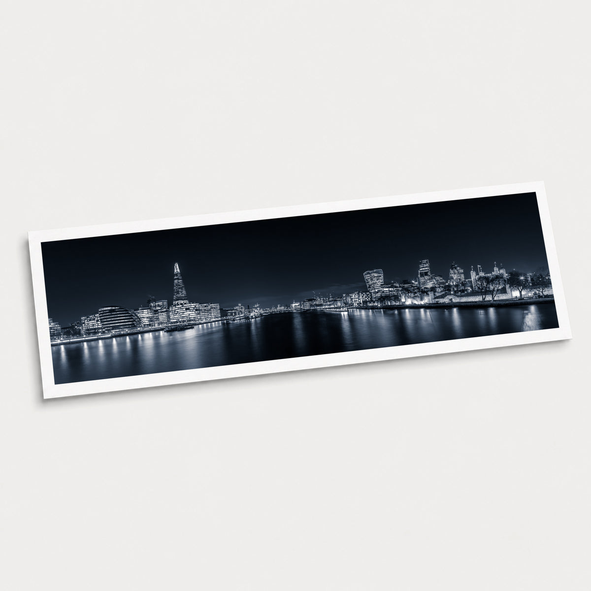 A photographic art print of London Illuminated, displayed at an angle on a light gray background.