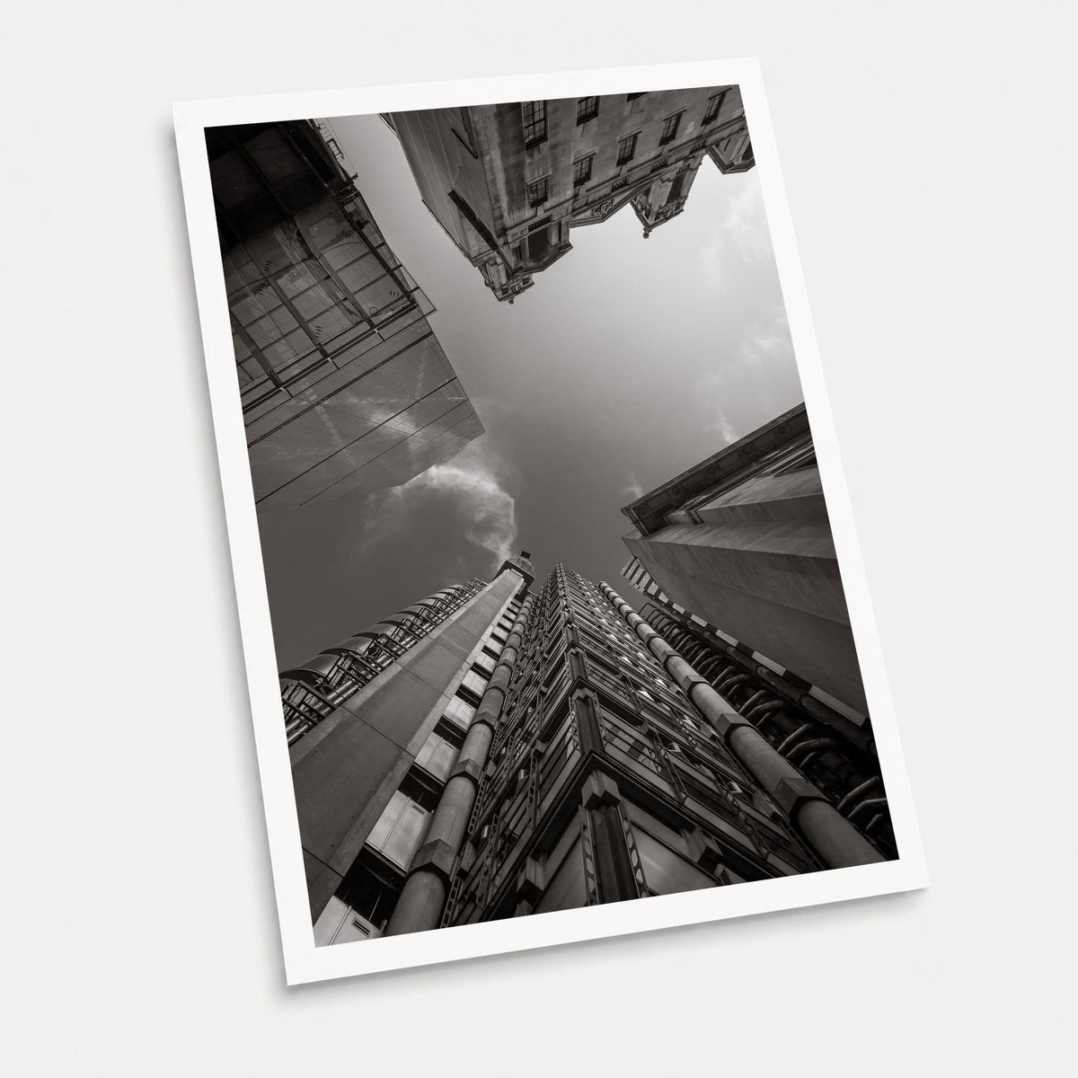A black and white photographic art print of Looking up at Lloyds, displayed at an angle on a light gray background.