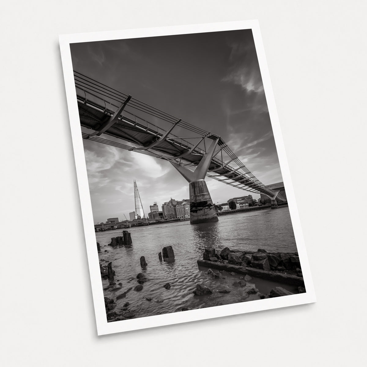A black and white photographic art print of Low Tide, displayed at an angle on a light gray background.