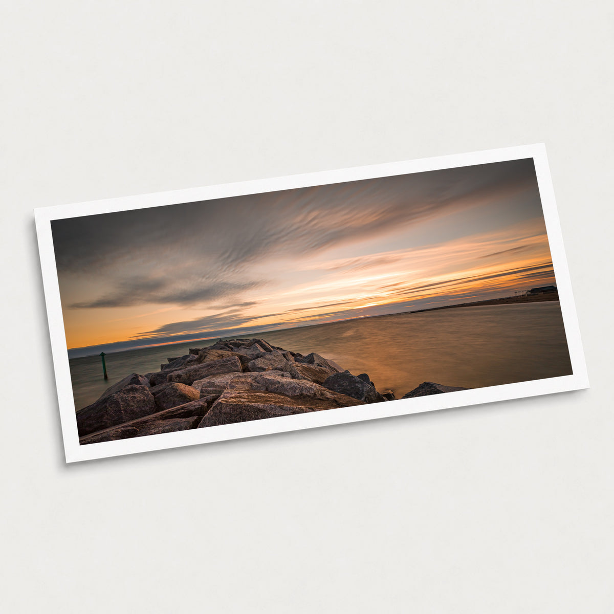 A photographic art print of Seascape Sunset, displayed at an angle on a light gray background.