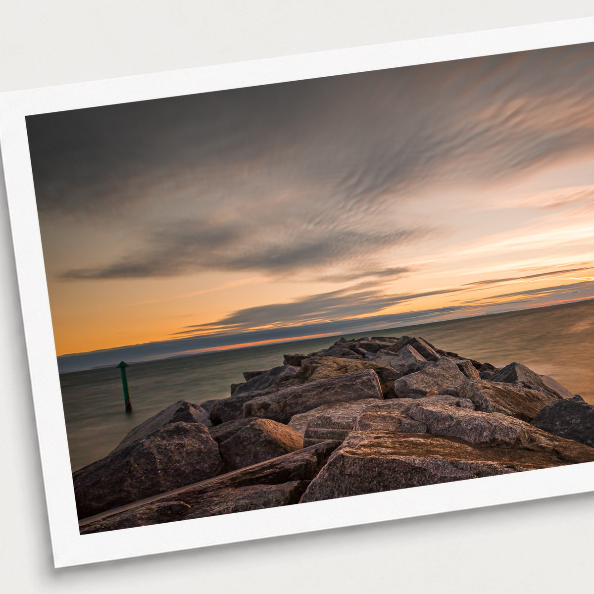 A photographic print of Seascape Sunset, shown with a white border and angled presentation on a light background.