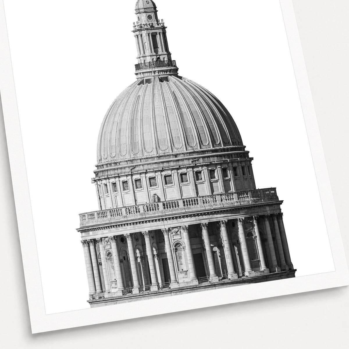 A black and white photographic print of St Paul's Cathedral, shown with a white border and angled presentation on a light background.