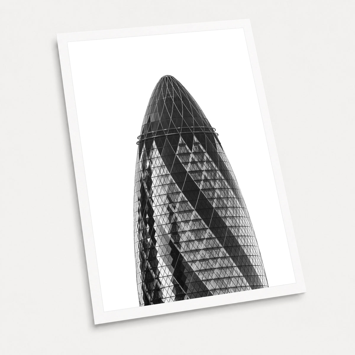 A black and white photographic art print of The Gherkin, displayed at an angle on a light gray background.