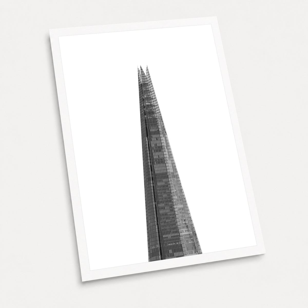 A black and white photographic art print of The Shard, displayed at an angle on a light gray background.
