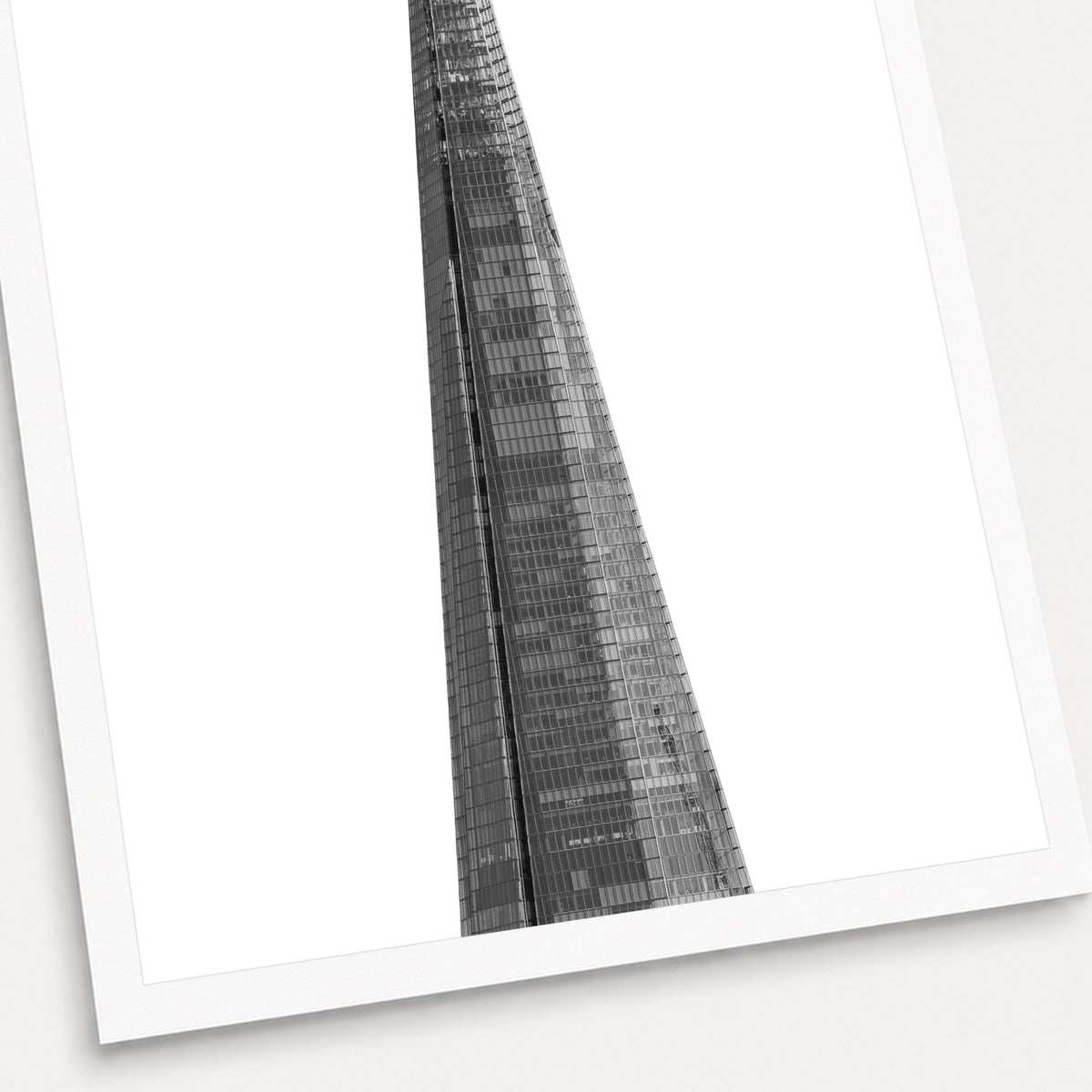 A black and white photographic print of The Shard, shown with a white border and angled presentation on a light background.