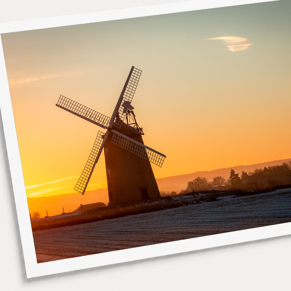 A photographic print of Windmill Sunrise, shown with a white border and angled presentation on a light background.